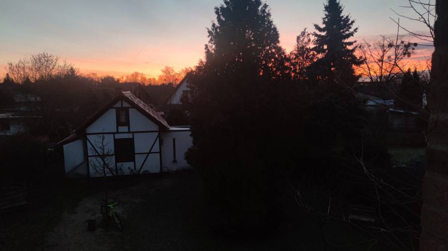 Das Fachwerkhaus im Winter bei Sonnenuntergang mit Schnee auf der Wiese