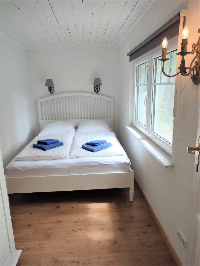 Schlafzimmer mit Bett und Fenster zum Garten