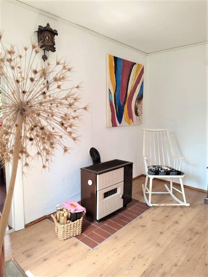 Kaminofen im Wohnzimmer mit Pusteblumen-Deko und Gemälde